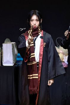 a woman dressed in harry potter costume holding a wand