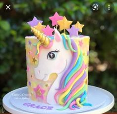 a unicorn cake is decorated with stars and icing