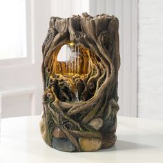 a vase made out of wood and rocks with a waterfall in the center surrounded by trees