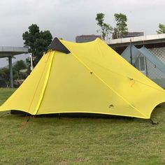 a yellow tent sitting on top of a lush green field