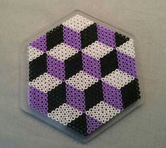 a purple, black and white hexagonal object made out of legos on a gray surface