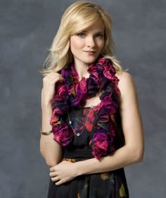 a woman with blonde hair wearing a purple scarf