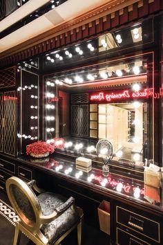 a vanity with lights and a chair in front of it