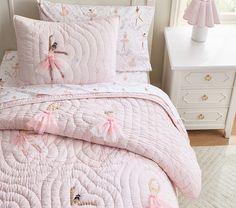 a pink ballerina comforter set on a white bed