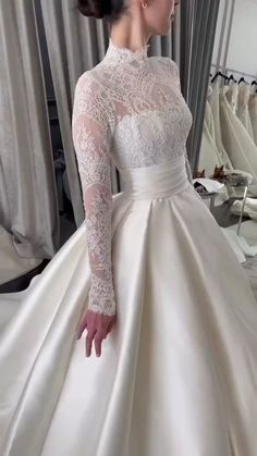 a woman in a wedding dress looking at her reflection