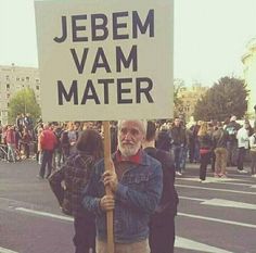 a man holding a sign that says jebem vam matter