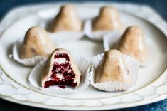 four desserts on a white plate with red and white frosting in the middle