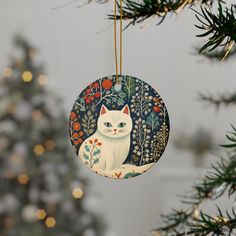 a white cat ornament hanging from a christmas tree