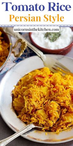 a white plate topped with yellow rice next to two bowls filled with other food items