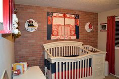 a baby's room with red, white and blue decor on the brick wall