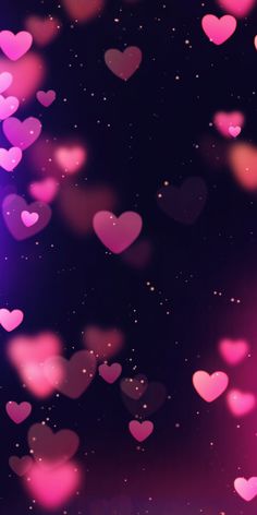 many pink hearts floating in the air on a black background with stars and sparkles