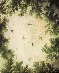 birds flying in the air above trees and branches on a painted wallpapered ceiling