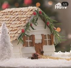 a gingerbread house decorated with icing and pine cones