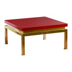 a red and gold coffee table sitting on top of a white floor