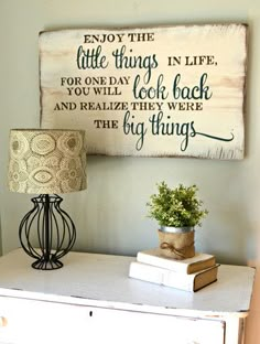 a white dresser topped with a lamp next to a sign that says enjoy the little things in life