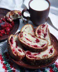 slices of bread with raspberry filling on a plate next to a cup of milk