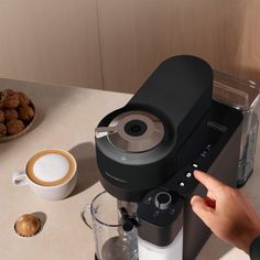 a person is pressing buttons on a coffee maker