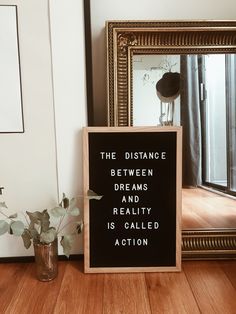 a sign sitting on top of a wooden floor next to a mirror