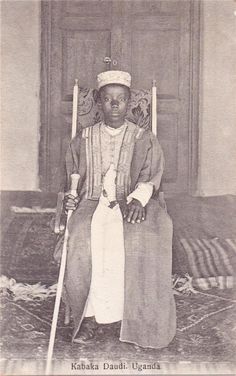 an old black and white photo of a person sitting on a chair with a cane