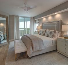 a bedroom with a bed, dressers and mirror in it's center area