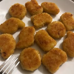 some fried food on a white plate with a fork