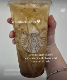 someone holding up a starbucks drink with the caption, brown sugar shaker espresso w cold foam and caramel drizzle