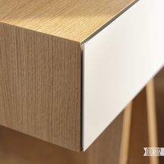 a close up view of a wooden cabinet with white drawers and wood grained edges