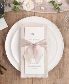 the wedding stationery is laid out on a wooden table