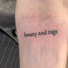 a person with a tattoo saying beauty and rage