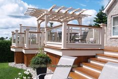 a patio with chairs and a pergolan on the top deck, next to a house