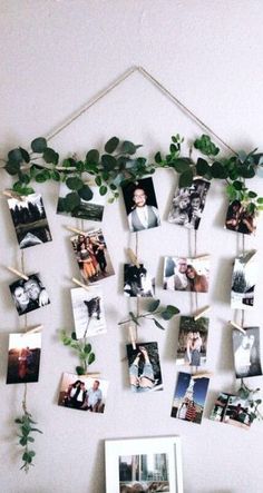 a white wall with pictures hanging from it's sides and plants growing on the side