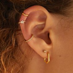 a close up of a person's ear with three different types of piercings