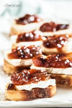 there are many small pieces of bread with jam on it and the words brie and fig crostini above them