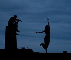 two people are silhouetted against the night sky with their arms in the air as they jump