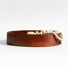 a wooden bowl with white beads in it