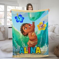 a woman holding up a blanket with an image of a cartoon character on the front