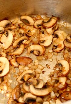 mushrooms and onions cooking in a pot on the stove top, ready to be cooked