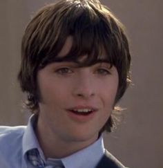 a young man wearing a blue shirt and tie