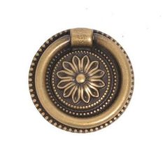 an antique brass cabinet knob with a flower design