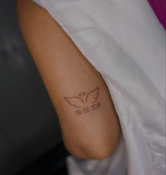 a woman's arm with a tattoo on it that reads 30 01 2009 and has an angel