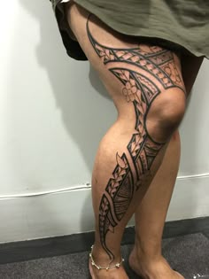 a woman's legs with an intricate tattoo design on the bottom part of her leg