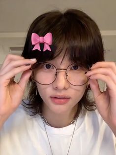 a woman with glasses and a pink bow on her head