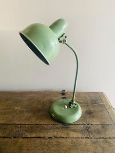 a green lamp sitting on top of a wooden table