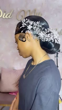 a woman wearing a hair comb with flowers on it's head in front of a wall