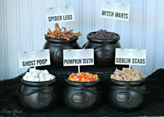 a table topped with black caulders filled with halloween treats