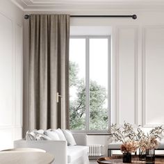 a living room filled with furniture and a window covered in drapes next to a white couch