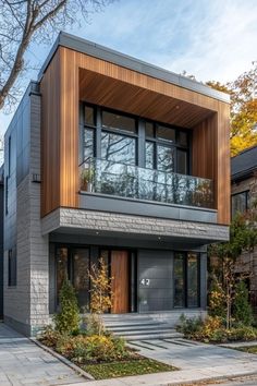 this modern house has two levels and is surrounded by trees, shrubs, and grass