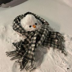 a snowman wearing a scarf and hat in the snow