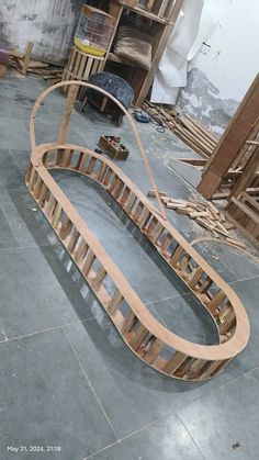 a curved wooden object sitting on top of a floor