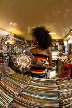 a woman standing in front of a large amount of records